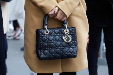 Frankie Morello moda defilesinden önce siyah deri çantalı ve bej ceketli kadın, Milan Moda Haftası tarzı. 