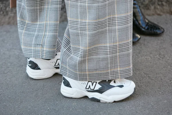 Mulher com tênis New Balance branco e preto e calças quadriculadas cinza antes Emporio Armani desfile de moda, Milan Fashion Week street style — Fotografia de Stock