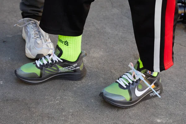 Uomo con scarpe da ginnastica trasparenti in schiuma Nike con calzini gialli prima della sfilata Fendi, Milano Fashion Week street style — Foto Stock