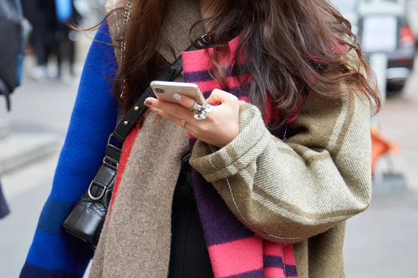 Женщина в розовом и бежевом пальто смотрит на смартфон перед показом мод Фрэнки Морелло, стиль улицы Недели Моды в Милане — стоковое фото