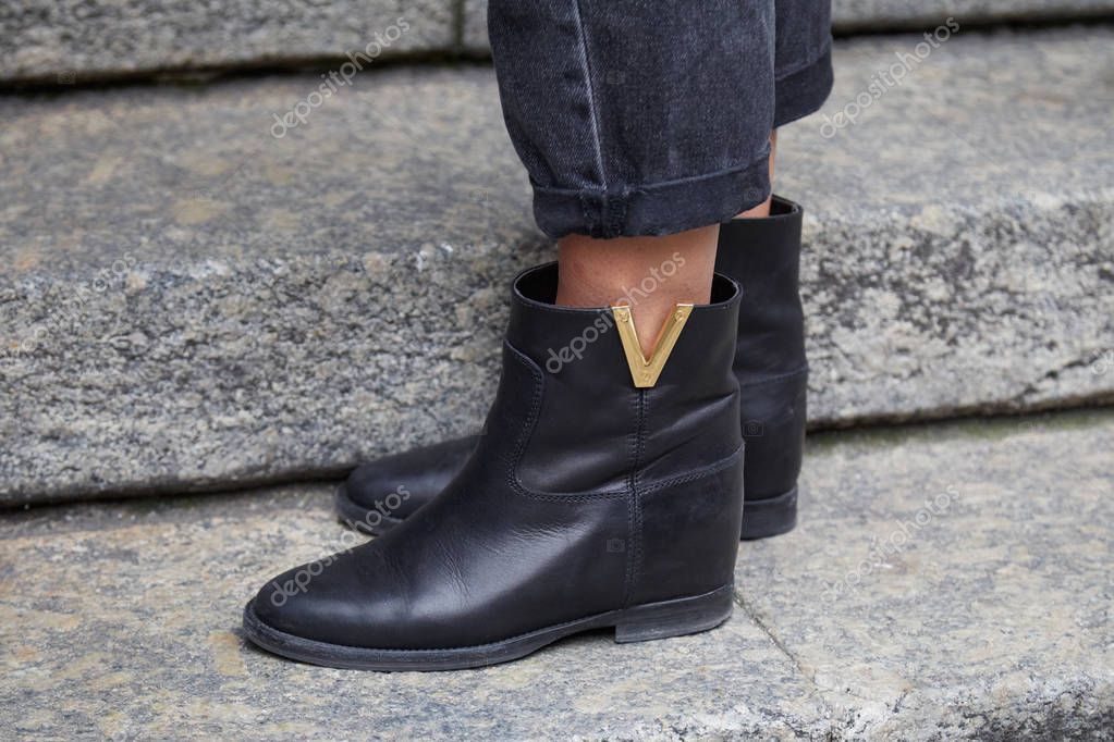 MILAN, ITALY - JANUARY 12, 2019: Man with black leather Louis Vuitton boots with golden logo before Frankie Morello fashion show, Milan Fashion Week street style