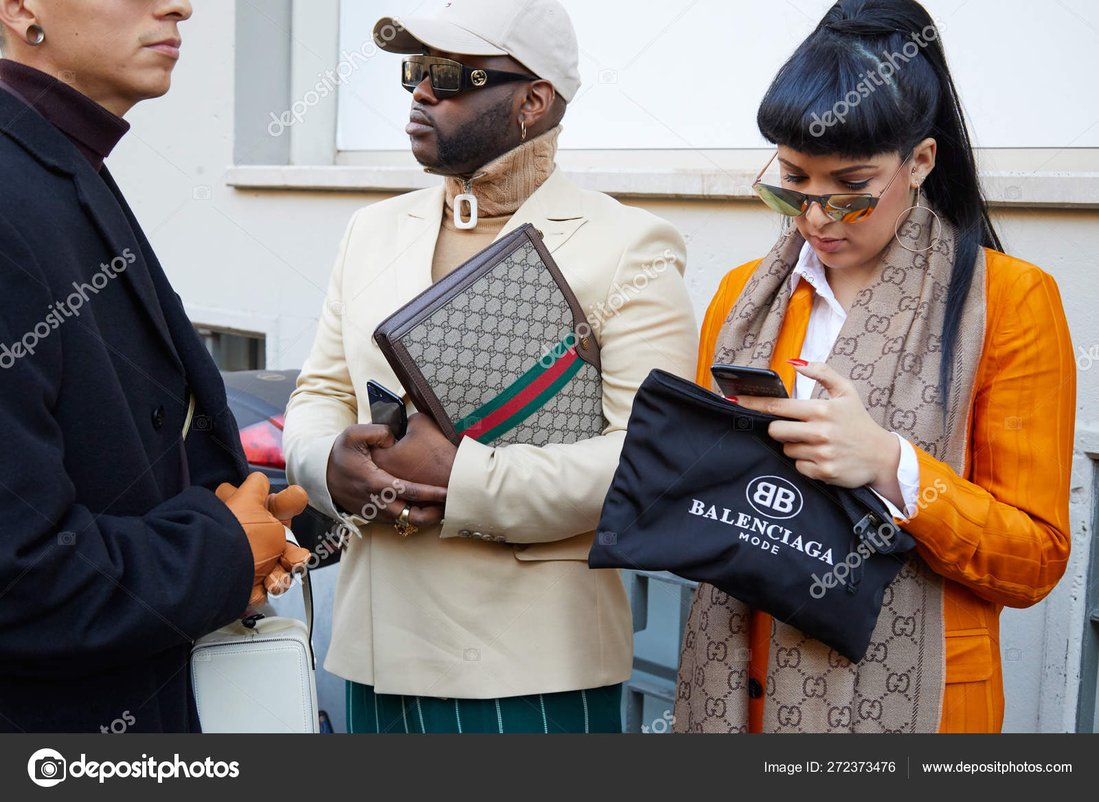 Woman with orange jacket and Balenciaga bag and man with Gucci bag before  John Richmond fashion show, Milan Fashion Week street style – Stock  Editorial Photo © AndreaA. #272373476
