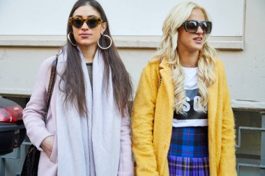 John Richmond moda defilesinden önce sarı ve açık mor ceketli kadınlar, Milan Moda Haftası tarzı. 