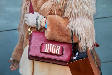 John Richmond moda defilesinden önce kırmızı deri çantalı ve kahverengi kürklü kadın, Milan Moda Haftası tarzı. 