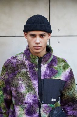 Siyah şapkalı ve mor, yeşil ve kahverengi, John Richmond defilesinden önce ceketli erkek modeli, Milano Moda Haftası sokak stili 