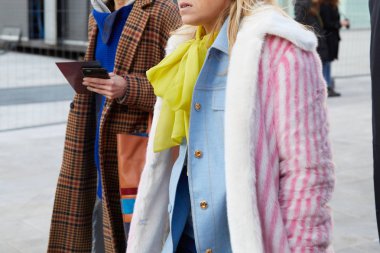 Neil Barrett defilesinden önce pembe ve beyaz kürklü ve sarı atkılı kadın, Milan Moda Haftası tarzı. 