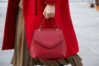 Neil Barrett moda defilesinden önce kırmızı paltolu ve kırmızı Grace Han deri çantalı bir kadın, Milan Moda Haftası tarzı. 