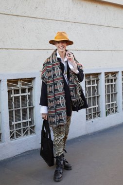 Spyder defilesi öncesi gülümseyen sarı şapkalı ve uzun atkı ile Adam, Milano Moda Haftası sokak stili 