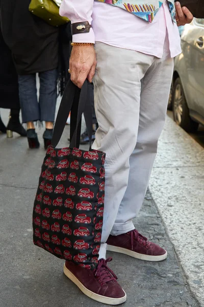 Hombre con pantalones grises y bolso con diseño de coches rojos antes del desfile de moda John Richmond, Milan Fashion Week street style —  Fotos de Stock