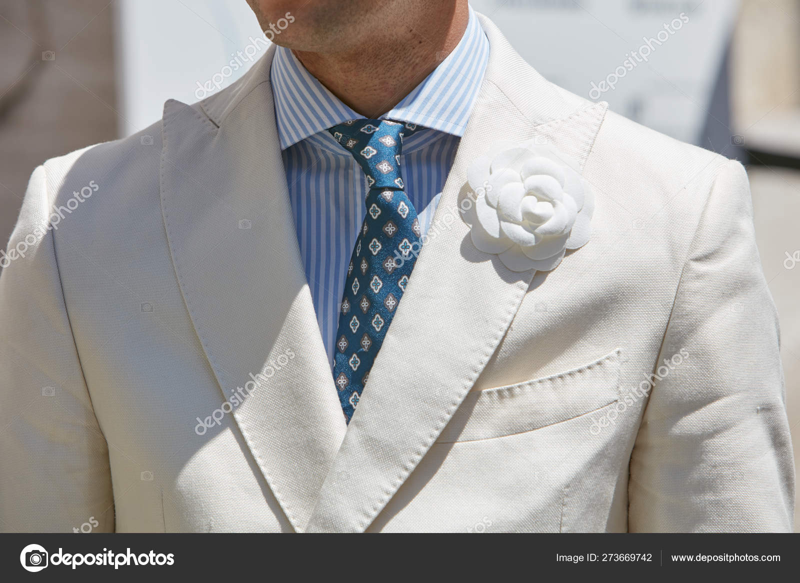 Elegante hombre con chaqueta blanca con flores y corbata azul