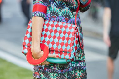 17 Haziran 2017 'de Milano' da, Emporio Armani moda defilesinden önce turkuaz ve kırmızı kareli çanta ve büyük yuvarlak bileziği olan kadın..