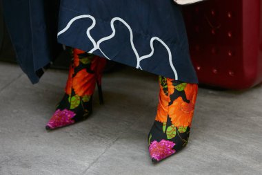 Emporio Armani moda defilesinden önce turuncu ve siyah çizmeli kadın, Milan Moda Haftası, 17 Haziran 2017, Milano.