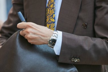 Emporio Armani defilesinden önce Rolex saatli ve kahverengi ceketli adam, Milano Moda Haftası sokak stili 17 Haziran 2017'de Milano'da.