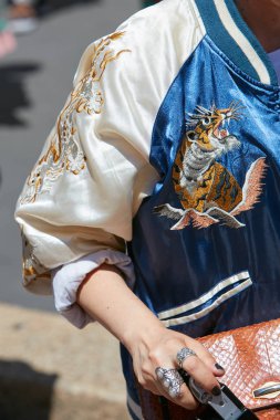 Salvatore Ferragamo moda defilesinden önce kaplan ve ejderhalı mavi saten ceketli kadın, Milan Moda Haftası tarzı 18 Haziran 2017 'de Milano' da.