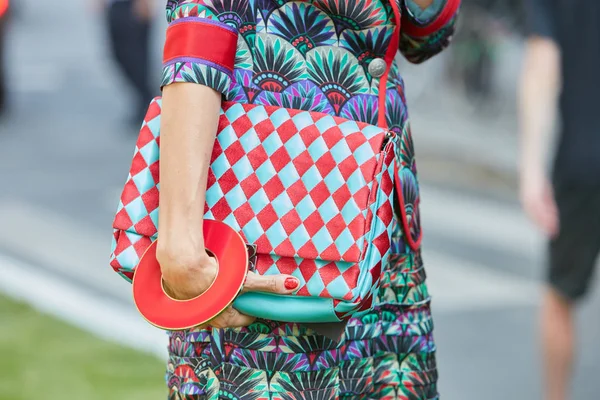 Donna con borsa a scacchi turchese e rossa e grande bracciale rotondo prima della sfilata di Emporio Armani, Milano Fashion Week street style il 17 giugno 2017 a Milano . — Foto Stock