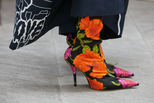 Nő magas sarkú csizma narancs és rózsaszín virágos dekoráció előtt Emporio Armani divatbemutató, Milánó Fashion Week utcai stílus június 17, 2017 Milánóban. — Stock Fotó