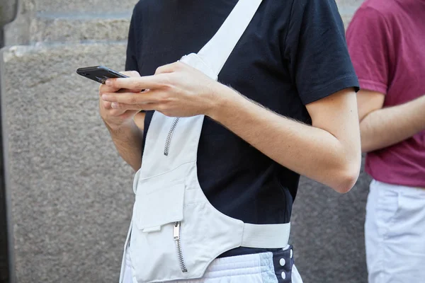 Hombre con el bolso blanco Les Hommes revisando el teléfono antes del desfile de moda Les Hommes, Milan Fashion Week street style el 17 de junio de 2017 en Milán . — Foto de Stock