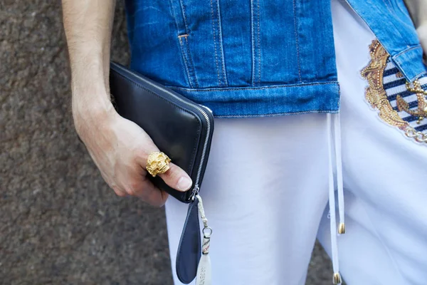 Uomo con anello teschio d'oro e pantaloni sportivi bianchi prima della sfilata Les Hommes, Milano Fashion Week street style il 17 giugno 2017 a Milano . — Foto Stock