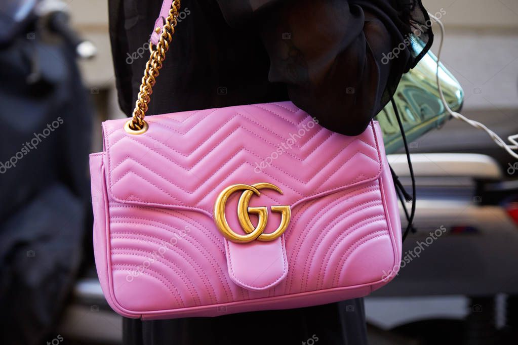 MILAN - JUNE 17: Woman with Gucci pink leather bag with golden chain before Versace fashion show, Milan Fashion Week street style on June 17, 2017 in Milan.