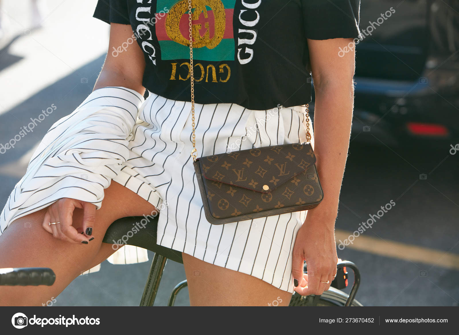 Woman with black Gucci t-shirt and Louis Vuitton bag before Prada