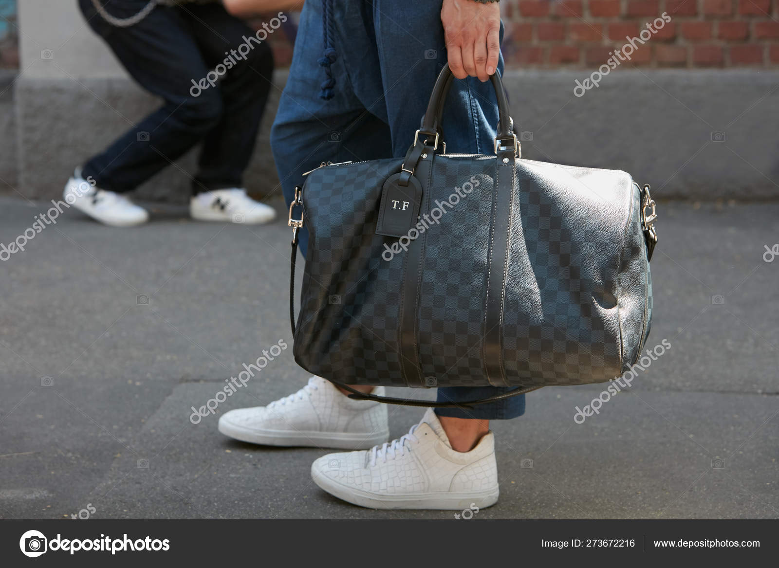Man with Louis Vuitton gray checkered bag before Fendi fashion
