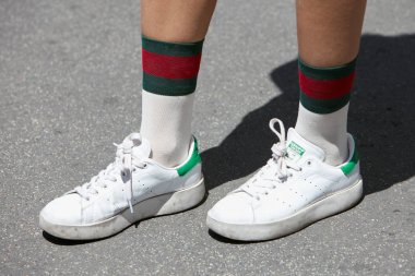 Beyaz ve yeşil Adidas Stan Smith ayakkabılı ve Gucci çoraplı kadın Salvatore Ferragamo moda defilesinden önce, Milan Moda Haftası sokak stili 18 Haziran 2017 'de Milano' da.