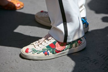 Salvatore Ferragamo defilesi öncesi çiçek süslemeli Gucci spor ayakkabılı adam, Milano Moda Haftası sokak stili 18 Haziran 2017'de Milano'da.