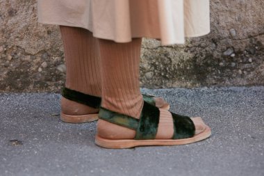 Salvatore Ferragamo defilesinden önce yeşil kadife sandaletli ve kahverengi çoraplı kadın, Milan Moda Haftası sokak stili 18 Haziran 2017, Milano.