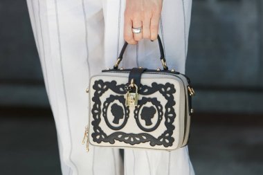 Giorgio Armani defilesinden önce siyah beyaz Dolce e Gabbana çantası olan kadın, Milano Moda Haftası 19 Haziran 2017 'de Milano' da.