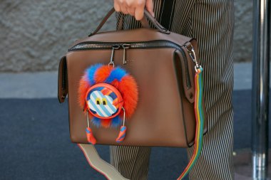 Fendi moda defilesinden önce renkli kuklalı kahverengi Fendi deri çantalı kadın, Milano Moda Haftası 19 Haziran 2017 'de Milano' da.