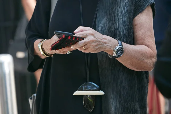 Vrouw met Breguet horloge controleren smartphone voor Giorgio Armani modeshow, Milaan Fashion Week straatstijl op juni 19, 2017 in Milaan. — Stockfoto