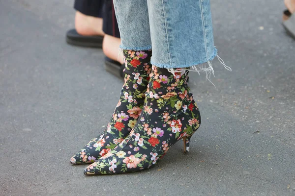 Woman with boots with floral decorations and torn jeans before Fendi fashion show, Milan Fashion Week street style on June 19, 2017 in Milan. — стокове фото