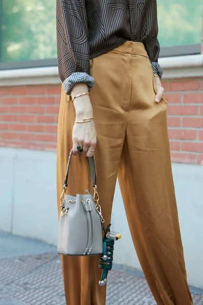 Mujer con pequeño bolso de cuero gris y pulseras Cartier de oro antes del desfile de moda Fendi, Milan Fashion Week street style on junio 19, 2017 in Milan . — Foto de Stock