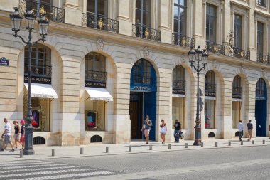 Paris 'te yer Vendome Louis Vuitton Dükkanı, güneşli bir yaz gününde geçen insanlar