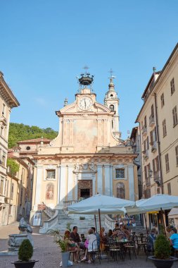 Moro meydanı güneşli bir yaz öğleden sonra kafe masalarında oturan insanlar ile, Mondovi mavi gökyüzü, İtalya.