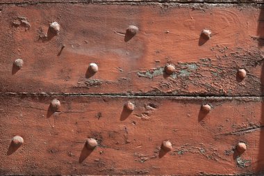 Eski ahşap, güneş ışığında çivi doku arka plan ile yontulmuş kapı