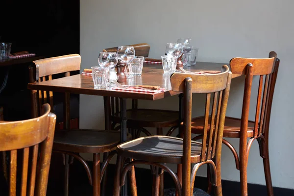 Hnědá dřevěná restaurace stoly a židle za slunného letního dne — Stock fotografie