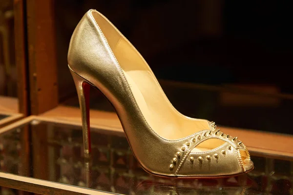 Christian Louboutin high heel golden shoes with studs in fashion luxury store in Monte Carlo, Monaco. — Stock Photo, Image