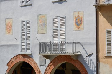 Mondovi, İtalya güneşli bir yaz gününde freskler ve kırmızı tuğla kemer ile soluk mavi bina cephe