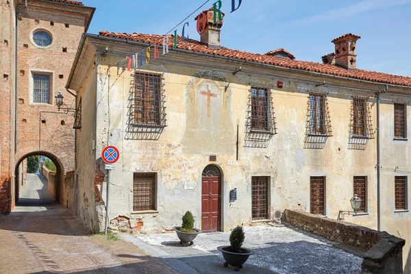 Antico edificio con affresco con croce in una soleggiata giornata estiva, cielo azzurro a Mondovi, Italia . — Foto Stock