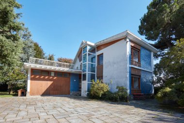 Güneşli bir yaz gününde bahçe, asansör ve garaj ile Villa, İtalya'da açık mavi gökyüzü