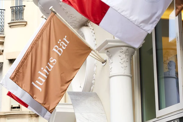 Monte Carlo, Monako güneşli bir yaz gününde Julius Bar özel banka işareti bayrak. — Stok fotoğraf