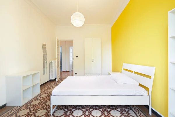 Обновленная спальня с белыми и желтыми стенами — стоковое фото
