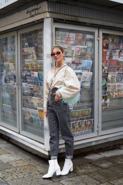 MİLAN, İTALYA 24 Eylül 2020: Koyu gri pantolonlu ve turkuaz tüylü kadın Max Mara moda defilesinden önce, Milan Moda Haftası tarzı