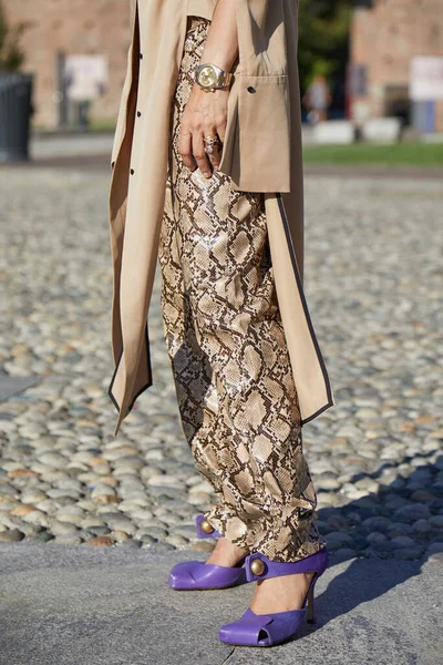 MİLAN, İTALYA 23 Eylül 2020: Rolex Daytona saati, yılan derisi pantolonu ve mor topuklu ayakkabıları olan kadın Alberta Ferretti defilesinden önce, Milan Moda Haftası tarzı