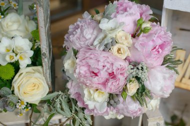 Soluk pembe tonlar buket peonies, Frezya'lar ve yeşil yapraklı aksesuarları gelin veya nedime tarafından taşınan bir buket olarak ya da özel günler, düğün veya olaylar için hazırlanan kadeh kırpılmış 
