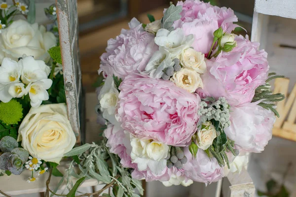 Soluk pembe tonlar buket peonies, Frezya'lar ve yeşil yapraklı aksesuarları gelin veya nedime tarafından taşınan bir buket olarak ya da özel günler, düğün veya olaylar için hazırlanan kadeh kırpılmış 