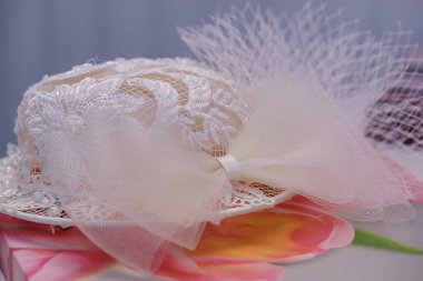 Çiçekli kumaş üzerinde eski moda bir kadın düğün aksesuar dinlenme beyaz nakışlı şapka