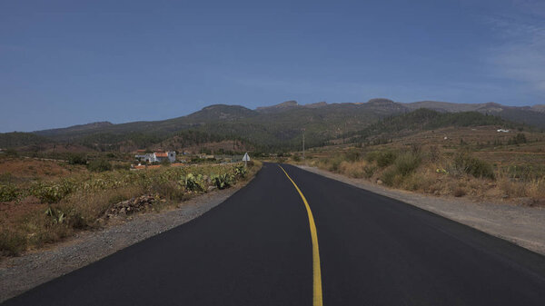 Пустая дорога через муниципалитет Арона, окруженная виноградниками, террасами и дикой эндемичной флорой, вид на Национальный парк Тейде с крупнейшим вулканом в Испании, на Тенерифе, Канарские острова
