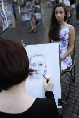 Piazza Navona, Roma - 4 Temmuz 2015: genç bir esmer kadın portresi Piazza Navona, sokak sanatçıları, satıcılar ve oyuncular arasında popüler bir kare çizim kadın sanatçı